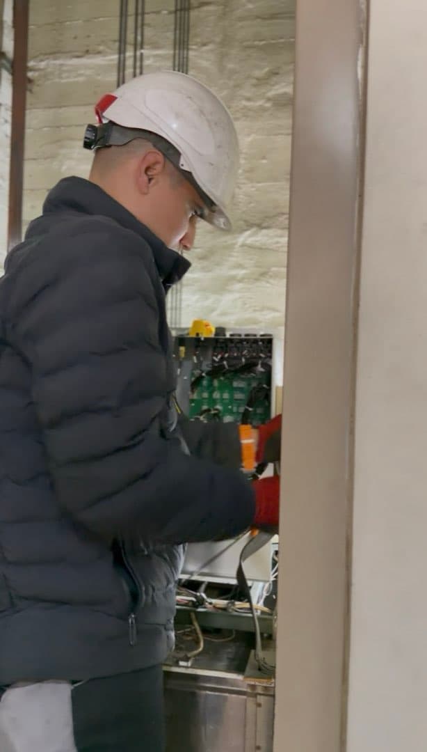 Técnico de Venechi revisando el tablero eléctrico de un ascensor