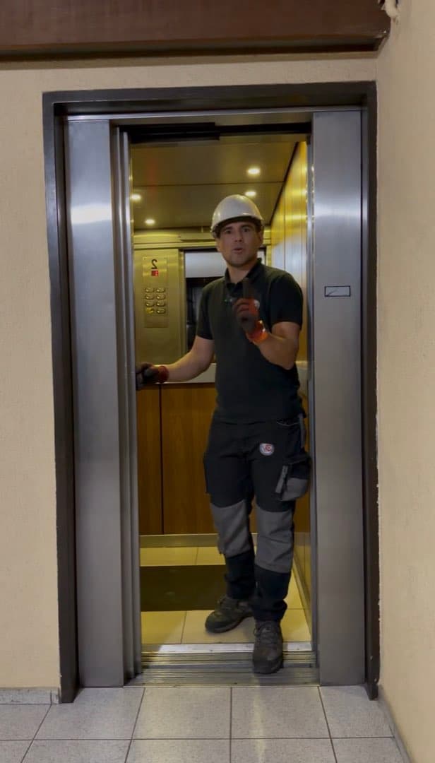 Técnico de Venechi dentro de una cabina de ascensor con las puertas abiertas